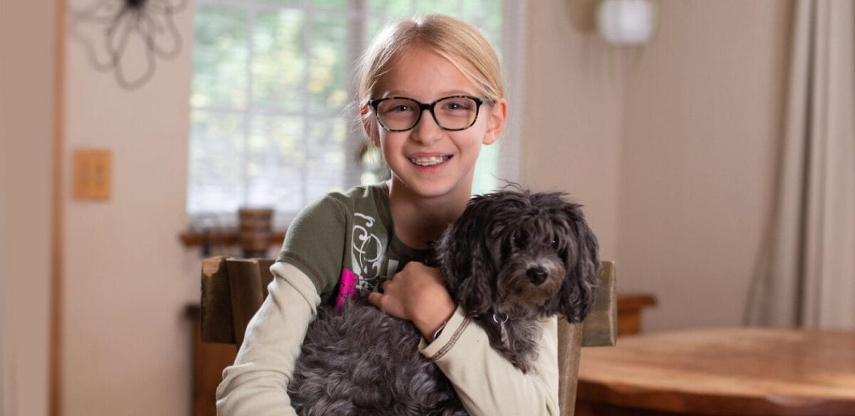 Student holding her dog at home